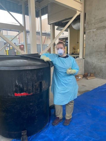 ADI Sustainability Intern Kristin Hutchinson pictured in PPE gear to prevent potential chemical exposure from the process of sorting manufacturing waste during the 2022 waste audit.
